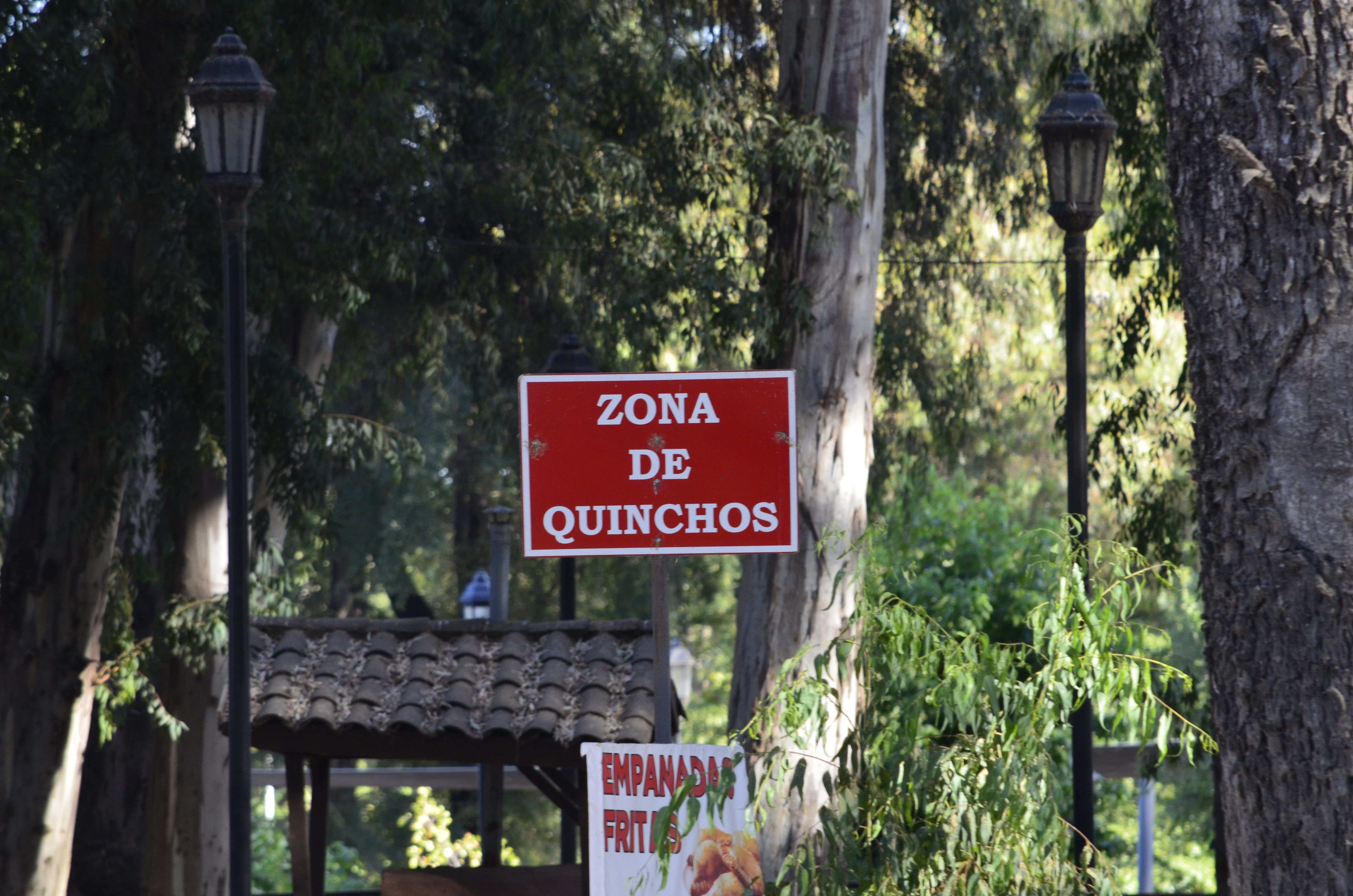 Fotografía de letrero rojo con letras blancas que destaca la zona de quinchos del parque